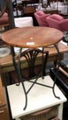 A small circular table with wrought iron legs