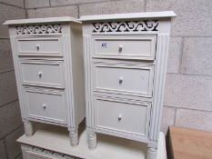 A pair of modern white bedside chests.