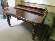 A mahogany extending dining table with 2 leaves.