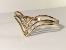 A 14ct gold diamond set cuff in 3 colours of gold set with 3 diamonds in a V design.