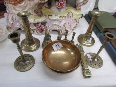 A pair of 19th century brass candlesticks, a brass 'prayer' bowl, nutcrackers, brass bell,