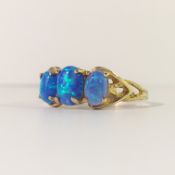 A 3 stone yellow gold opal ring, size M.