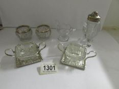 A pair of Walker and Hall salts on plated stands together with other condiment items.