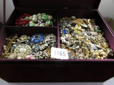 A large red velvet jewellery box containing a large quantity of costume jewellery.