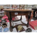 A circular oak occasional table with bow stretchers,