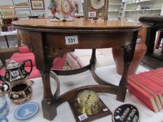 A circular oak occasional table with bow stretchers,