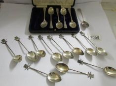 A loose set of 11 silver teaspoon featuring crossed rifles and target board along with a cased set