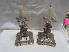 A pair of old Roccoco style silver plated candlesticks.