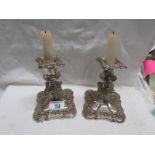 A pair of old Roccoco style silver plated candlesticks.