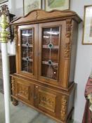 A Dutch carved oak dresser with leaded glass panels.