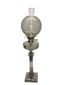 A silver plated Corinthian column oil lamp with glass font and etched shade.