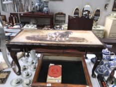 A coffee table with ploughing scene inset in top.