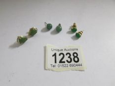 3 pairs of stud earrings with green stones in various settings.