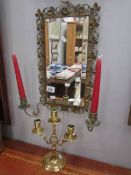 A bevel edged mirror in brass frame with candleholders and a 3 branch brass candelabra.
