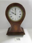 A mahogany 'balloon' clock with shell inlay.