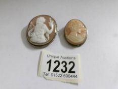 A vintage cameo in a white metal mount depicting a young woman with another cameo of a female