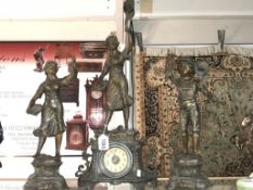 A 3 piece spelter clock garniture comprising clock surmounted figure and 2 side figures.