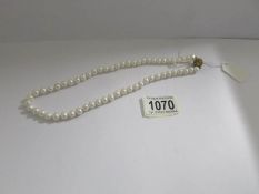 A cultured pearl necklace with stone set clasp.
