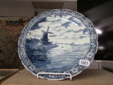 A large Delft blue and white charger depicting windmill scene.