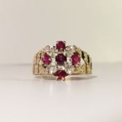 A ruby and diamond cluster ring in 9ct textured gold shank, H.