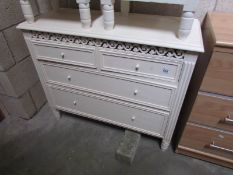A white 2 over 3 chest of drawers.