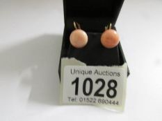 A pair of vintage coral set earrings in yellow metal.