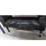 A black upholstered stool.