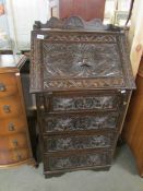 A carved oak bureau.