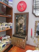 A novelty clock decorated with watch parts, a Kitkat clock and a brass magazine rack.