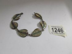 A pretty abalone shell bracelet formed as a row of leaves in silver.