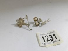 2 flower inspired brooches including one set with cultured pearls in silver.