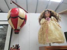 A collector's doll and a novelty model hot air balloon.