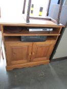 A pine television stand with DVD player and VHS recorder.