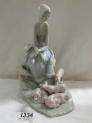 A Lladro figure of a girl with piglets.