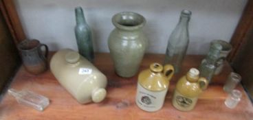 A shelf of stoneware and glass bottles.