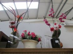 A quantity of vases with artificial flowers.