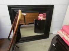 A wall mirror in black frame.