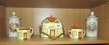 A 3 piece cottage ware tea set and a pair of lidded jars.