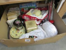 A box of sewing and knitting items including tins of buttons, patterns, wool etc.