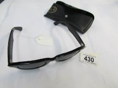 A pair of genuine Ray Ban sun glasses, marked RB on lens, small scuff to frame.