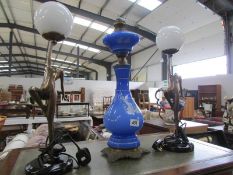 A pair of art deco style figural lamps and a blue glass lamp.