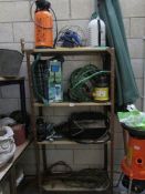 4 shelves of garden items including sprayers.