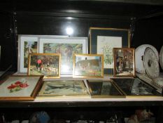 A shelf of framed and glazed prints.