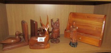 A shelf of wooden items including duck bookends, Buddha, letter rack etc.