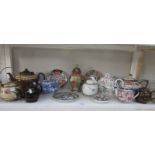 A shelf of tea ware including oriental teapots etc.