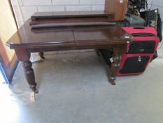 A mahogany dining table with 2 extra leaves.