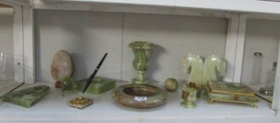 A shelf of onyx items including book ends, ash trays, urn, pen stand etc.