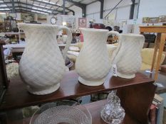 A set of 3 graduated white wicker pattern jugs.