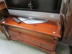 A stained pine television stand.