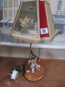 A vintage table lamp with shade surmounted robin.